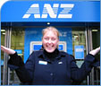 ANZ employee in front of ANZ ATM